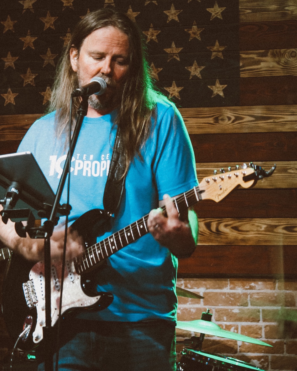 Travis Ross singing and playing guitar on stage